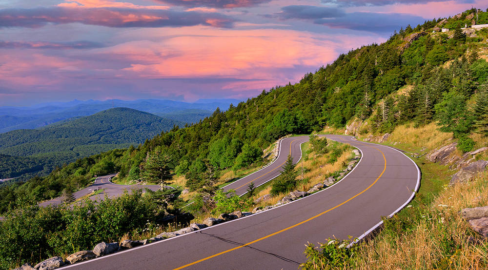 Winding scenic mountain road at sunset