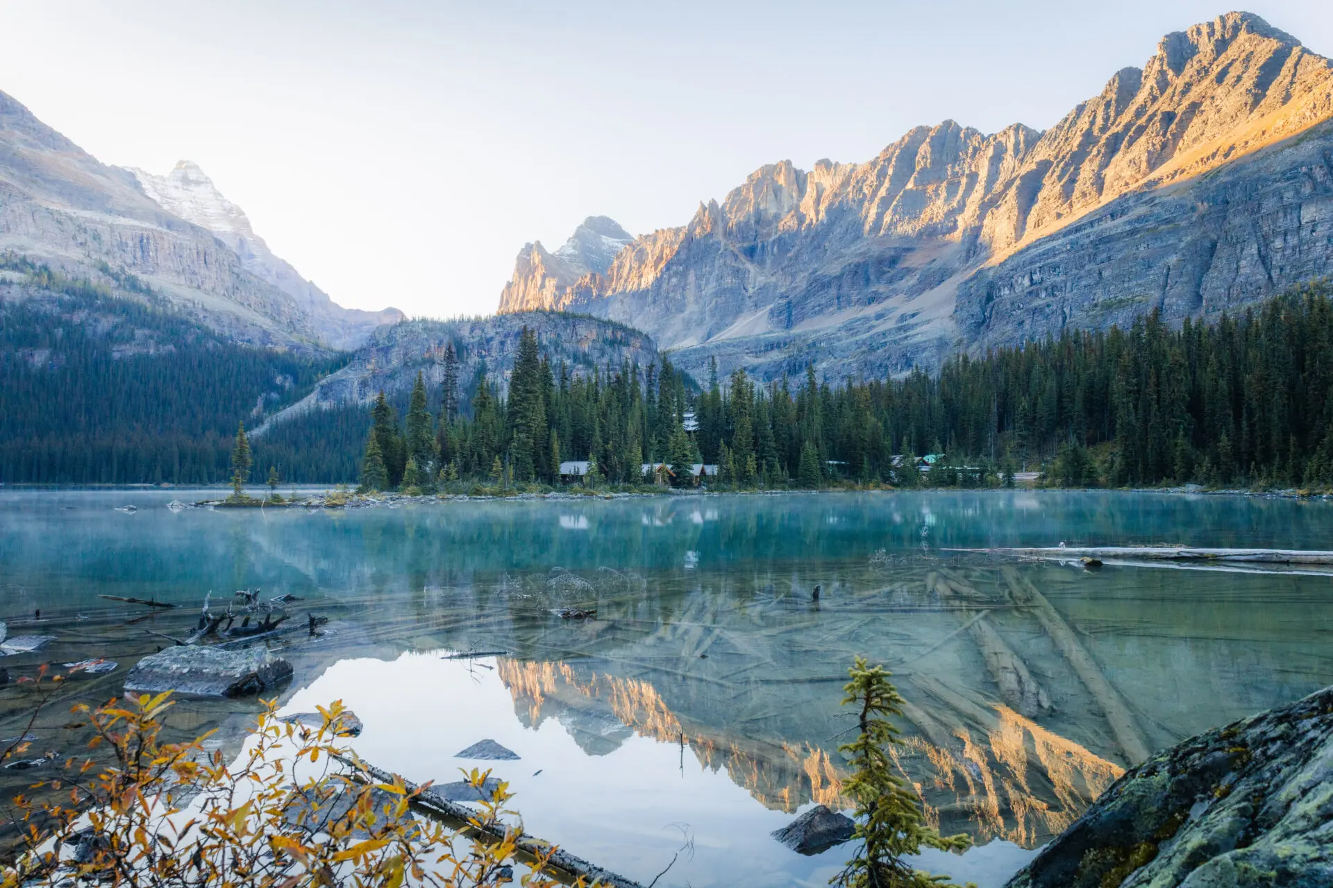 Turquoise alpine lake with mountains reflected at sunrise
