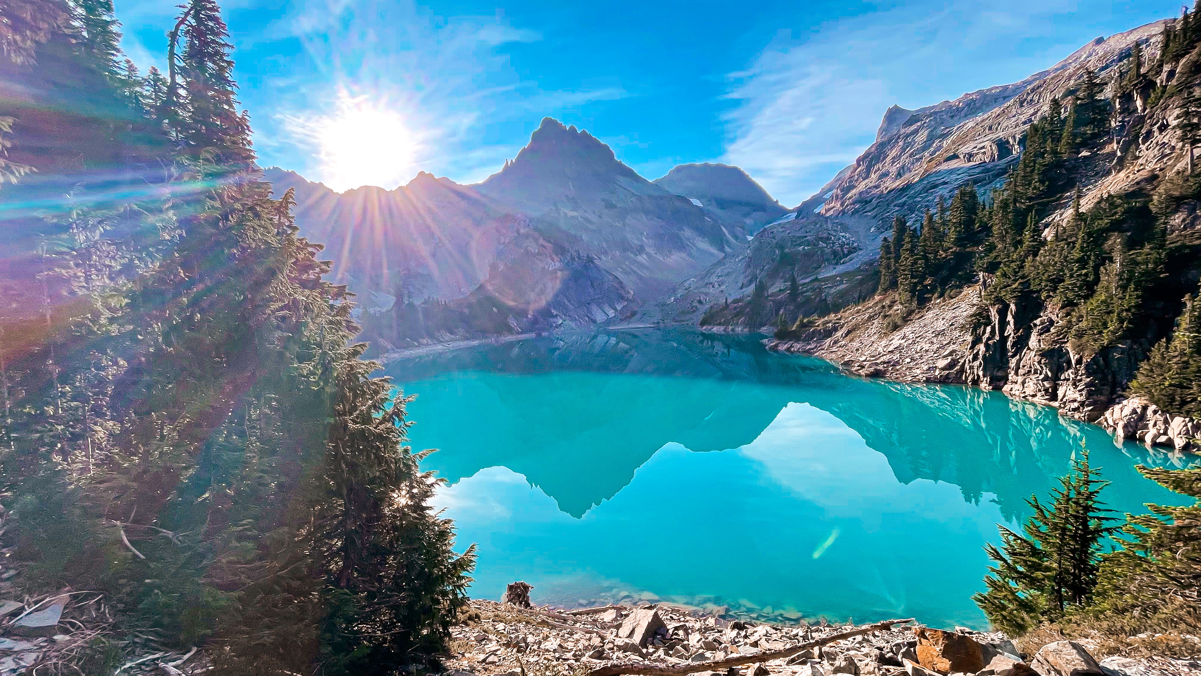 Alpine lake reflecting mountain colors with light ripples