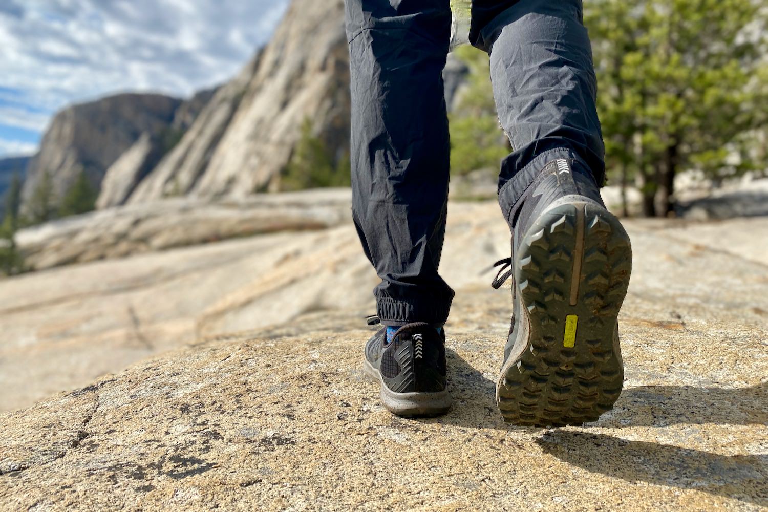 Close-up of hiking boots walking on a granite trail