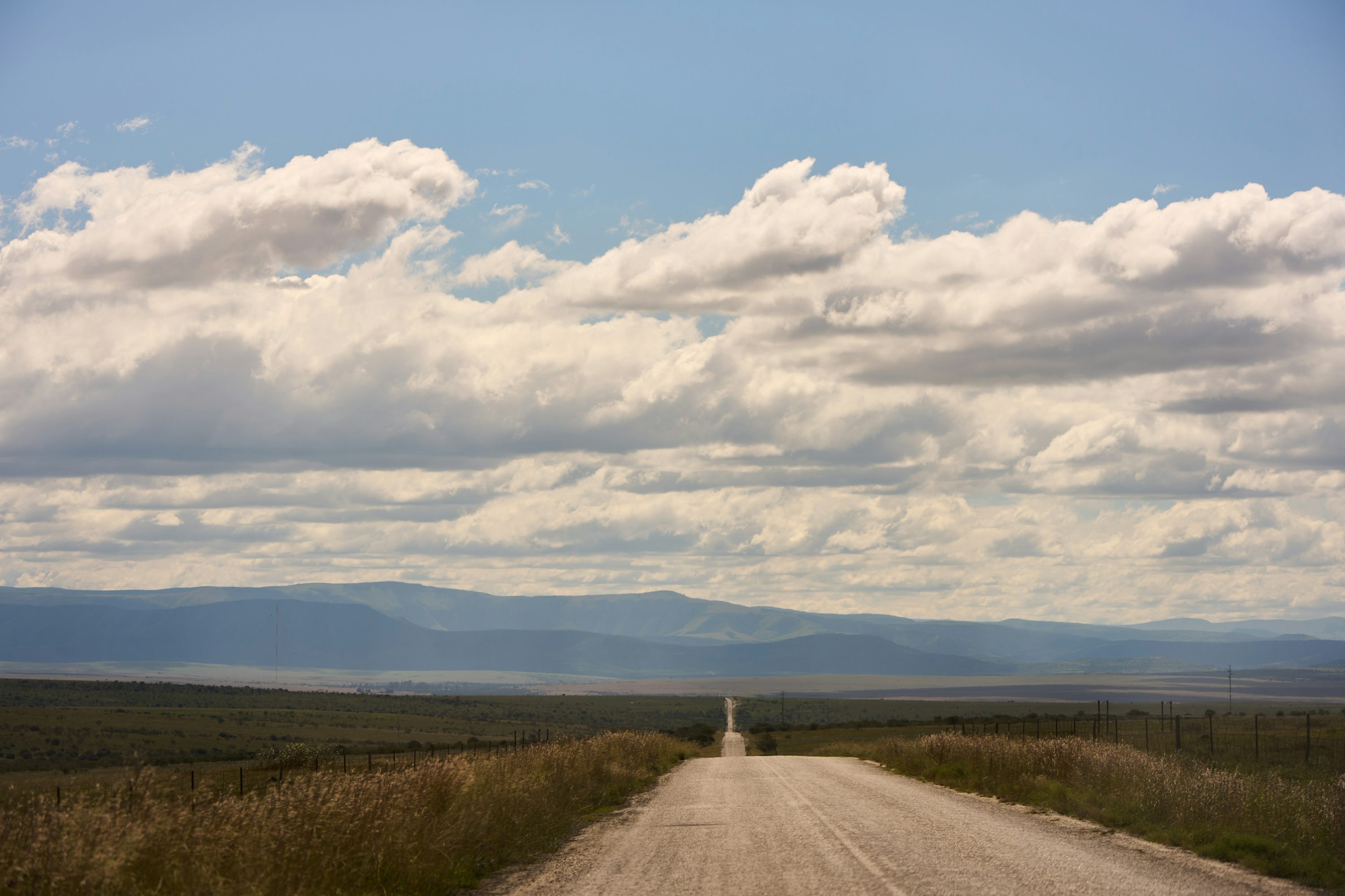 prairie highway with distant mountains on the horizon