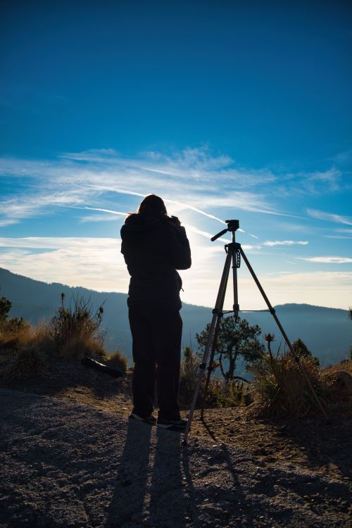 photographer setting up a tripod at sunrise